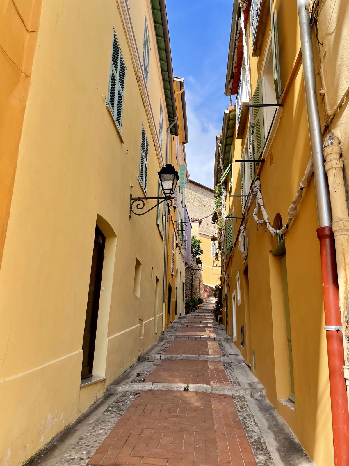Menton yellow street — narrow alley with deep golden walls, terracotta floor tiles